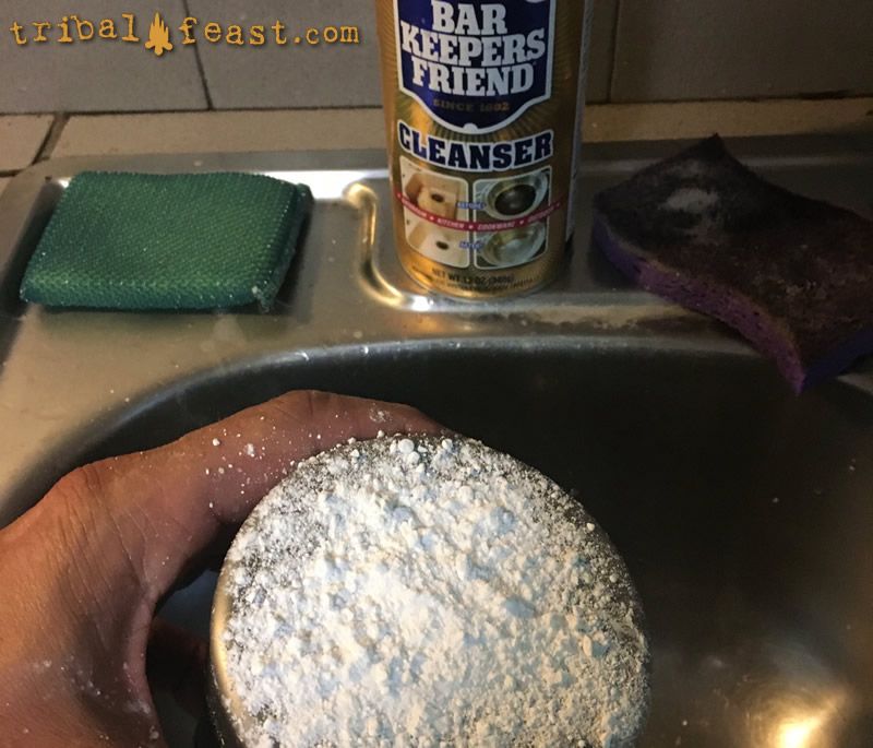 A heavy dose of Bar Keepers Friend on the bottom of a titanium pot covered in tar from cooking over a campfire. 